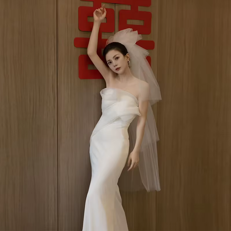 La robe de mariée légère en satin sans bretelles exude une aura amincissante parfaite pour les fêtes
