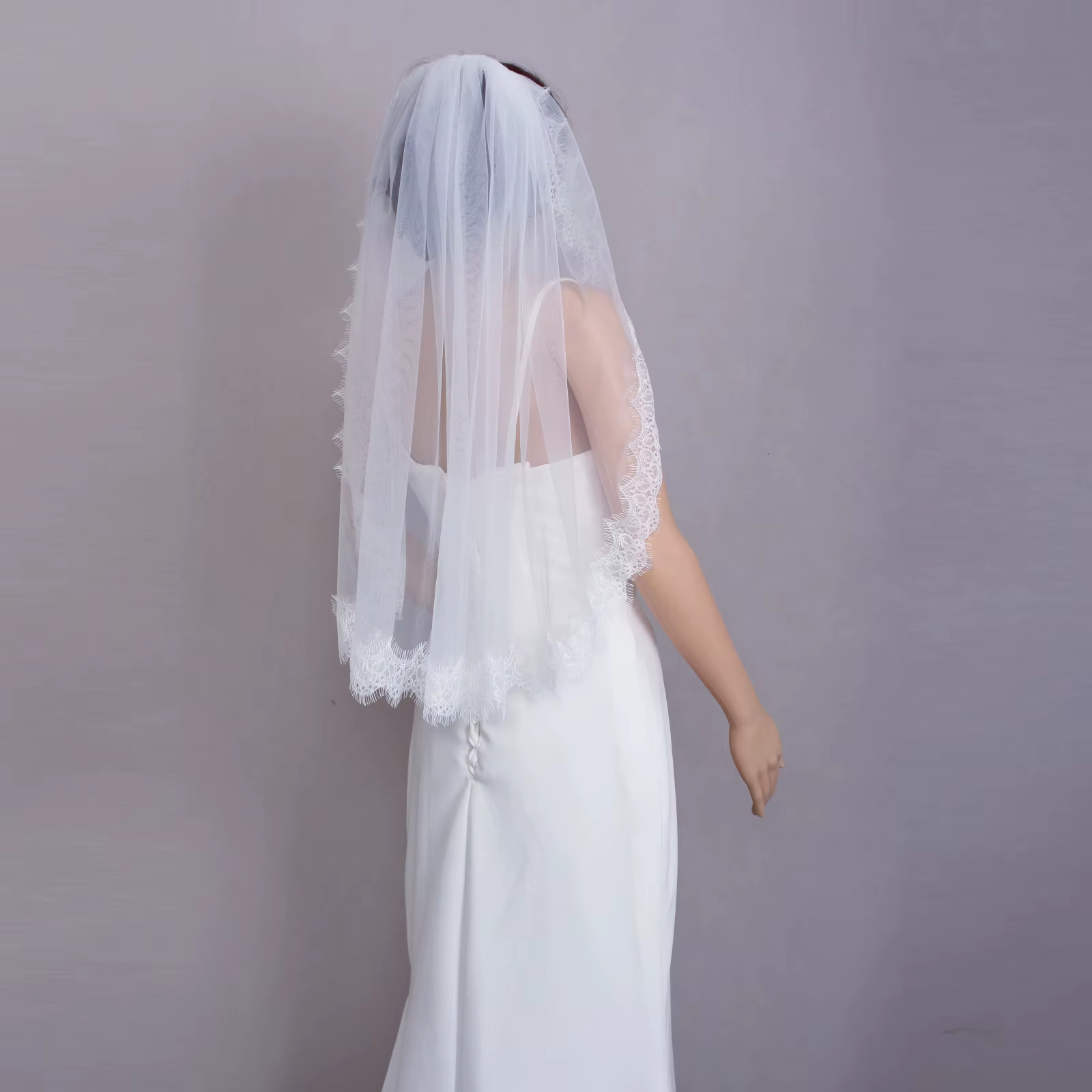 Charmant voile de mariée blanc fabriqué en tulle délicat avec une garniture en dentelle complexe, ac