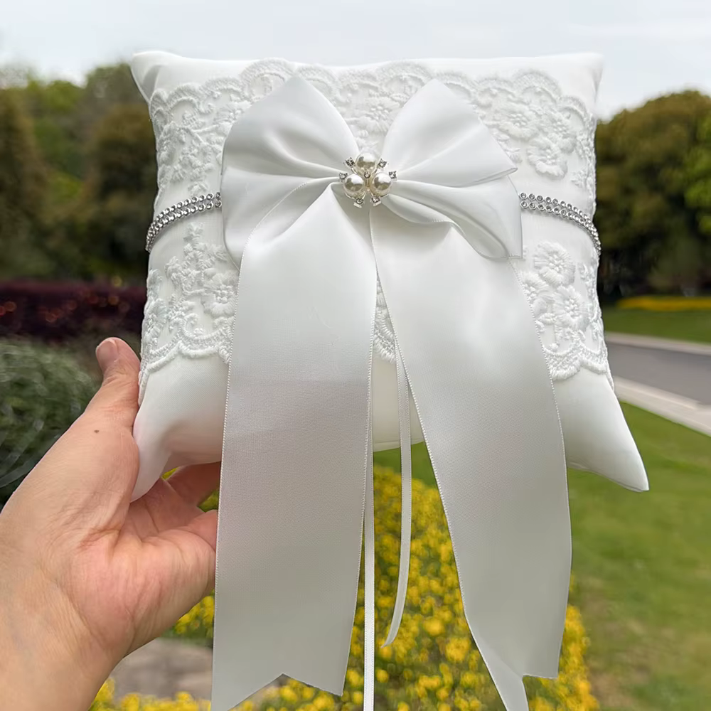 Coussin porte-alliances blanc en dentelle avec nœud et perle