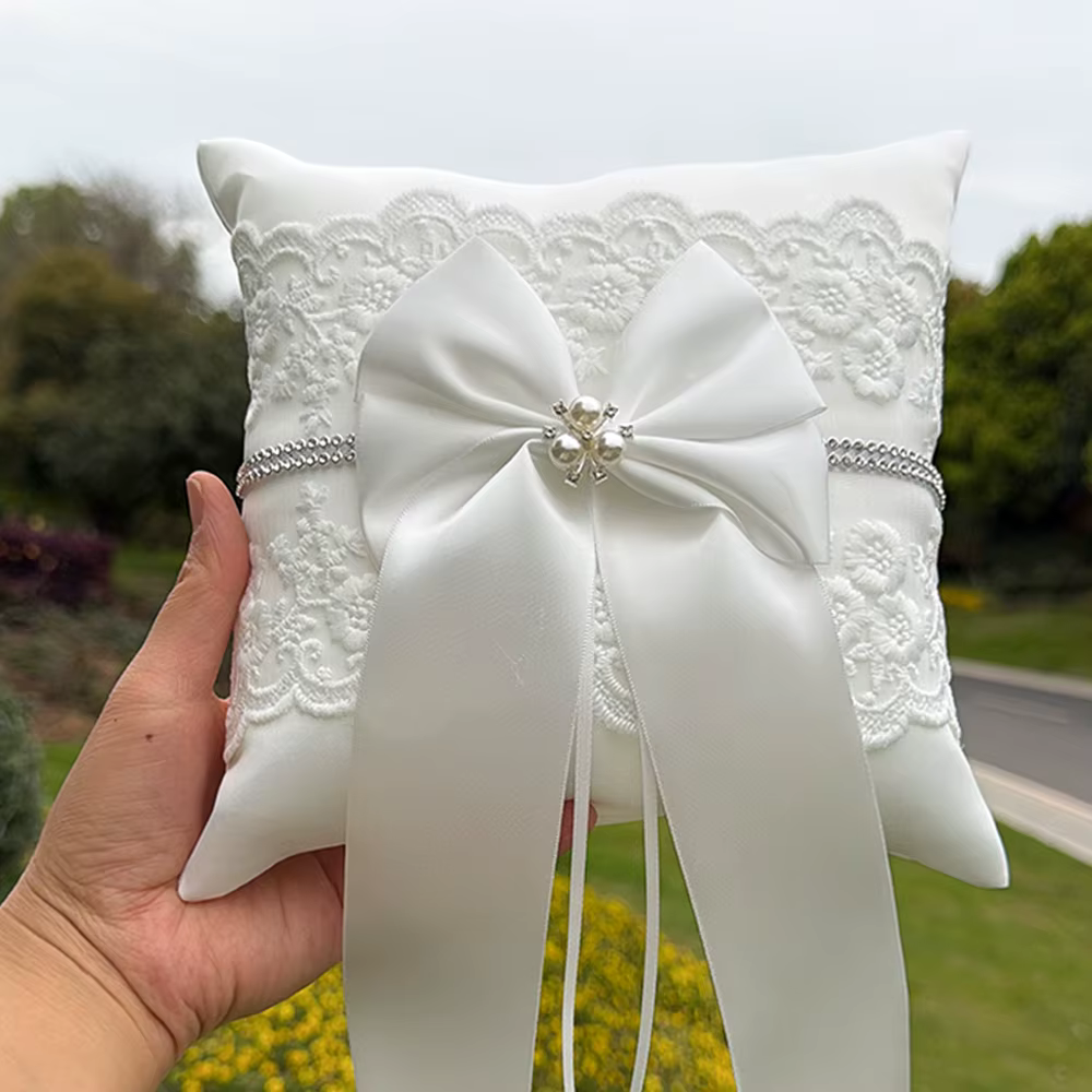 Coussin porte-alliances blanc en dentelle avec nœud et perle