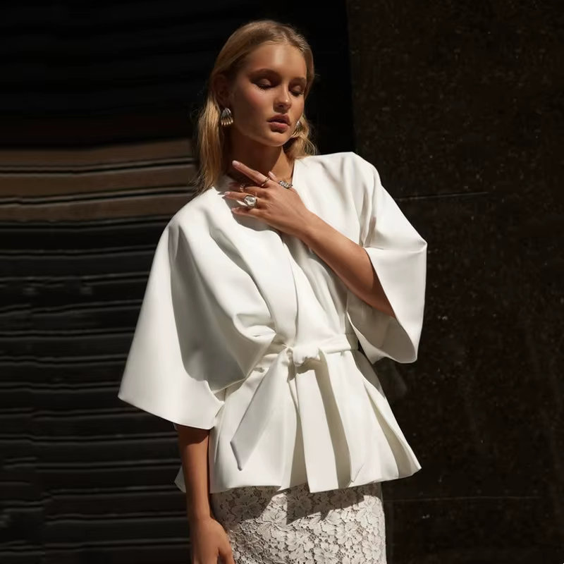 Ensemble deux pièces féminin élégant blanc blouse manches chauve-souris peplum jupe dentelle fente arrière tenue invité