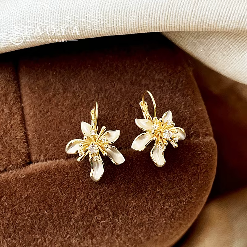 Élégantes boucles d'oreilles pendantes en émail blanc avec fleur