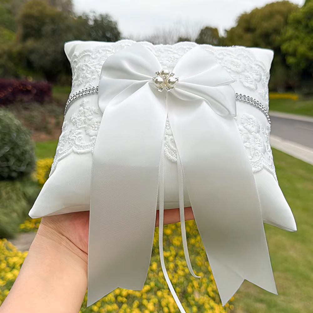 Coussin porte-alliances blanc en dentelle avec nœud et perle